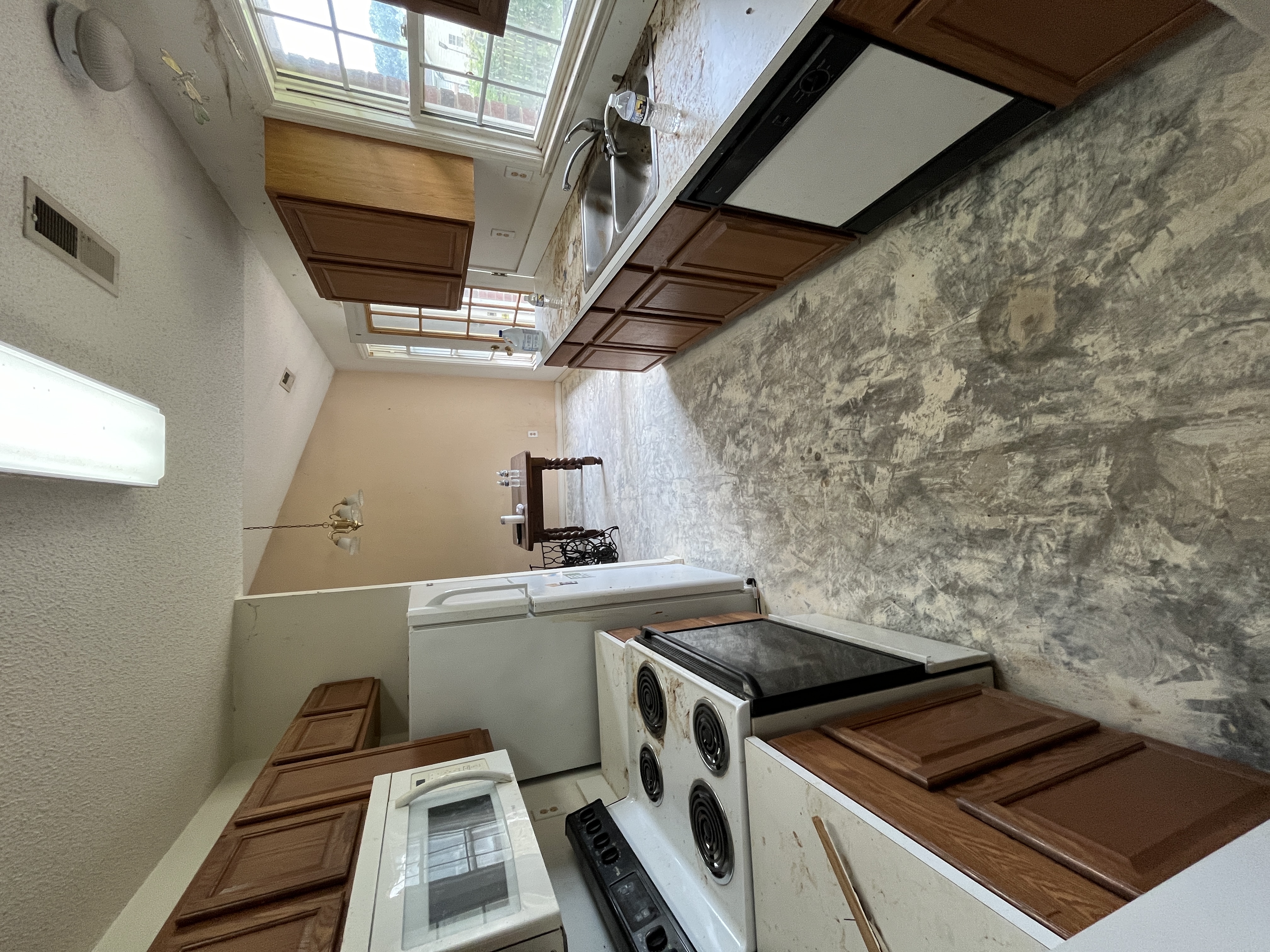 Kitchen — dated finishes, stripped flooring, belongings left in place, Monroe NC