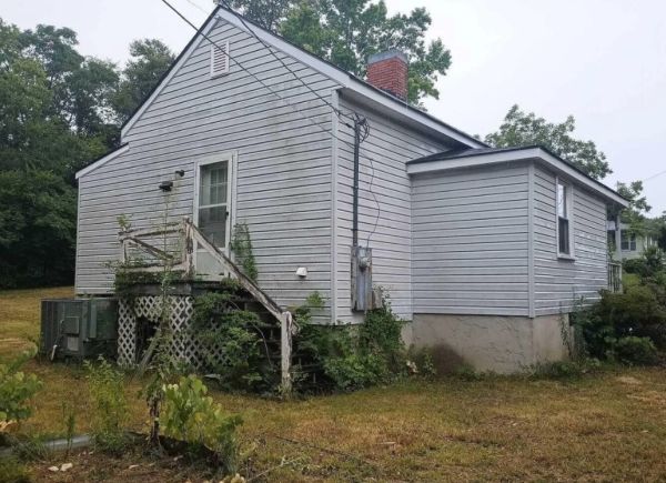 Exterior side — deferred maintenance, overgrown yard, Rockingham NC