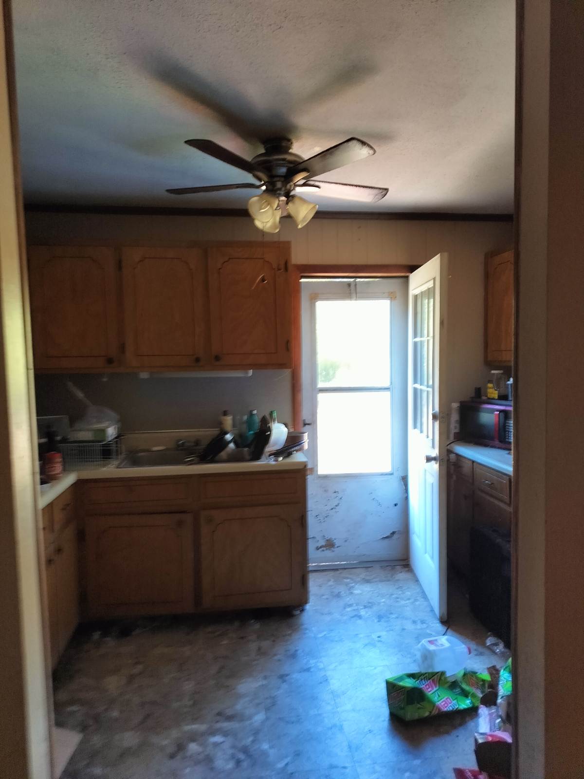 Kitchen full view — dated, cluttered, Stoneville NC