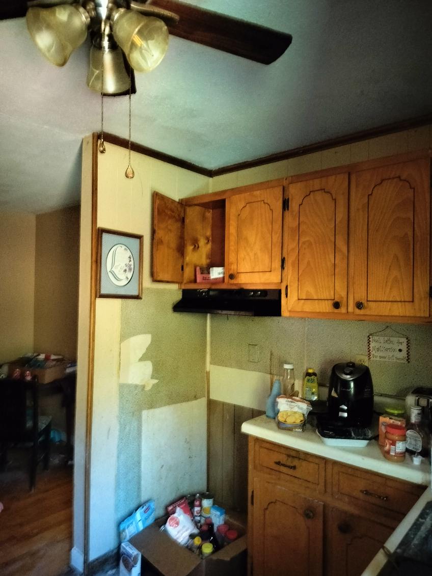 Kitchen — water/mold damage on walls, dated cabinets, Stoneville NC
