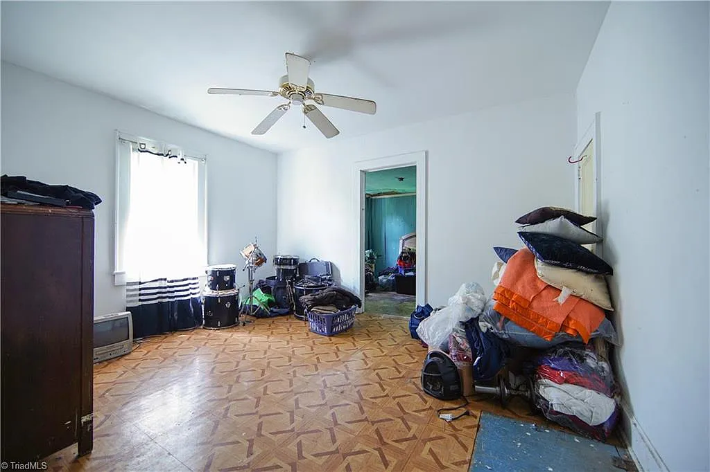 Bedroom — packed belongings, drum kit, original flooring, Winston-Salem NC